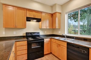 Kitchen with granite countertops, black appliances at Glisan Townhomes, 17218-17298 NE Glisan St, Gresham, Oregon 97230