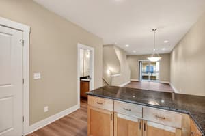 Kitchen with granite countertops and wood cabinets at Glisan Townhomes