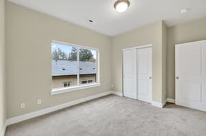 Bedroom with large window, carpeted floor at Glisan Townhomes, 17218-17298 NE Glisan St, Gresham, Oregon 97230