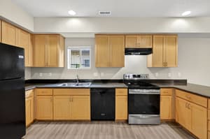 Kitchen with stainless steel appliances, wood cabinets at Glisan Townhomes, 17218-17298 NE Glisan St, Gresham, Oregon 97230